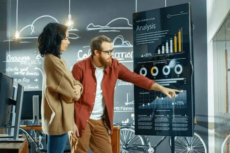 man pointing at computer charts