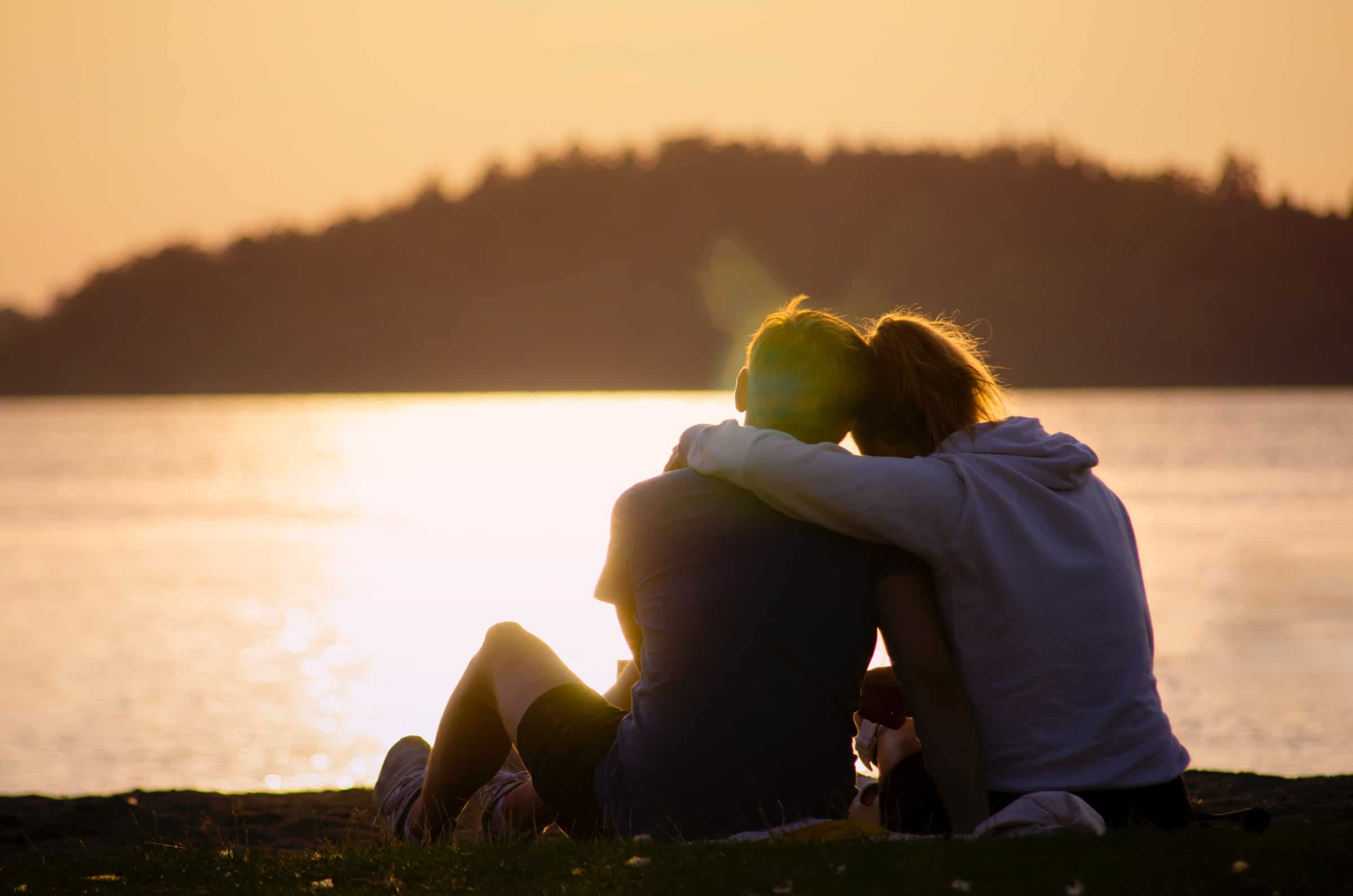 romantic couple watch sunset at beach