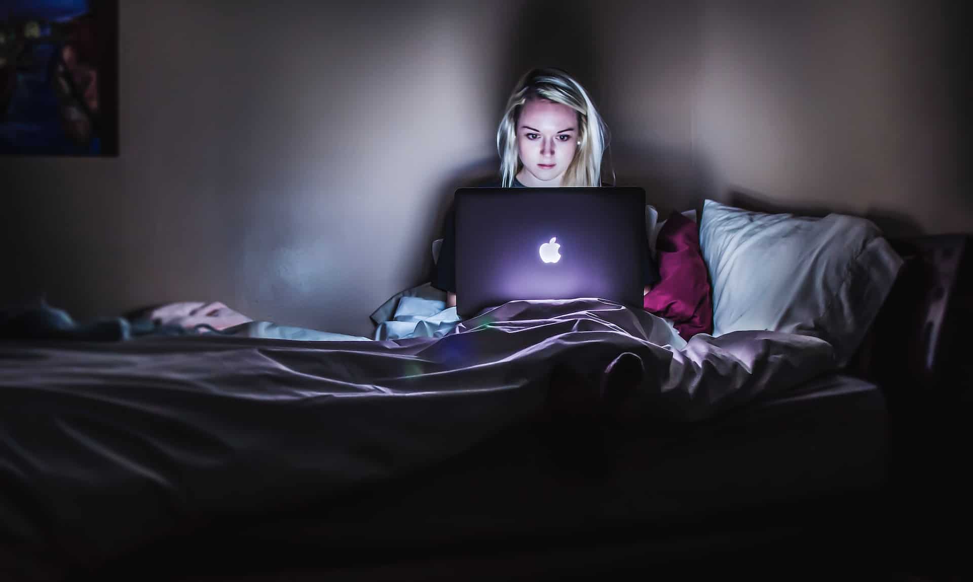 woman playing games on laptop at night