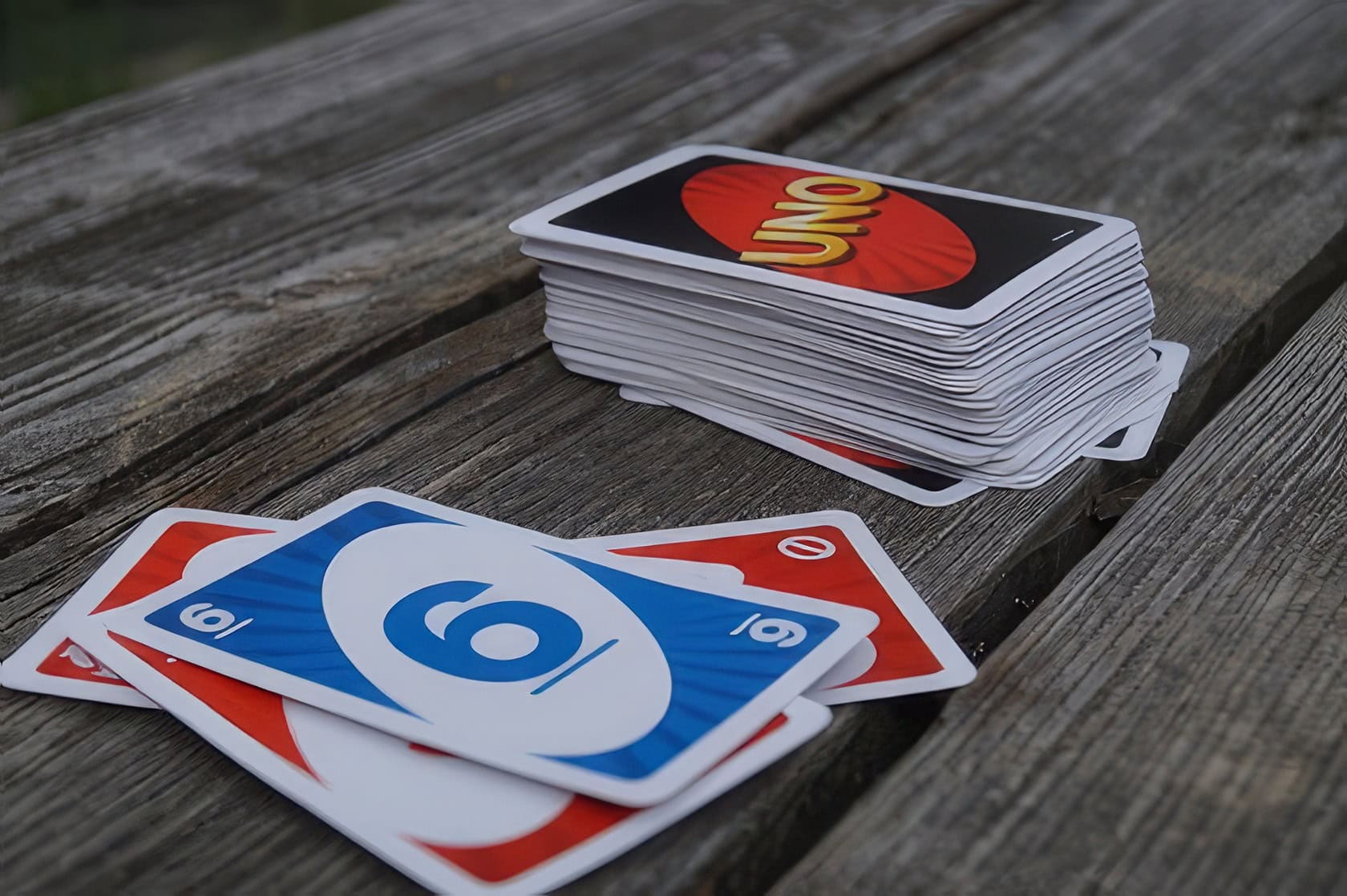 Five friends playing Uno at a wooden dining table with snacks and drinks. Can You Stack In Uno 1