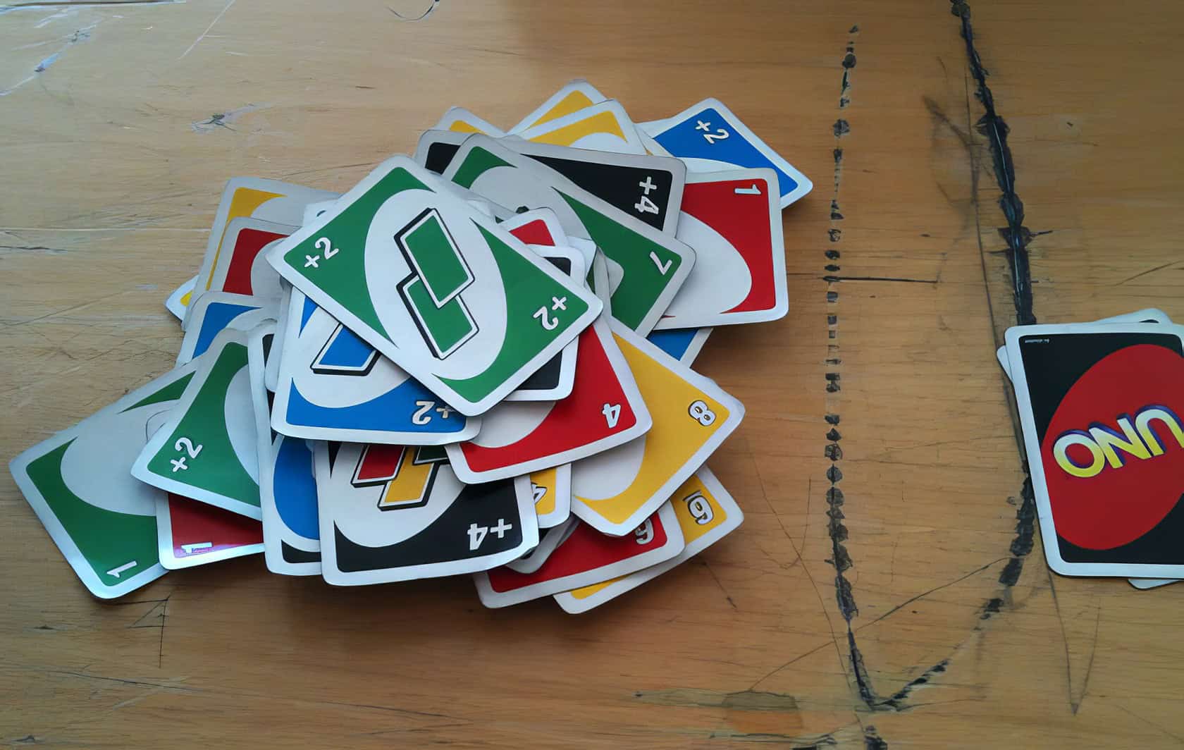 A group of six young adults play Uno Flip at a wooden table in a cozy living room. Can You Stack In Uno 2