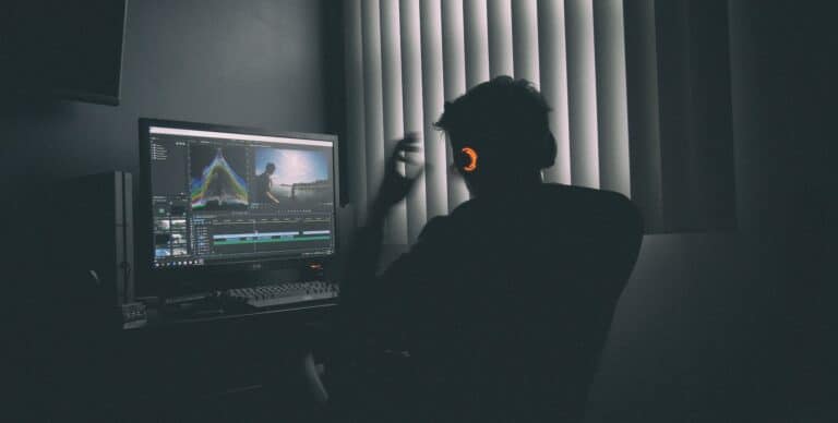 man editing video on computer screen