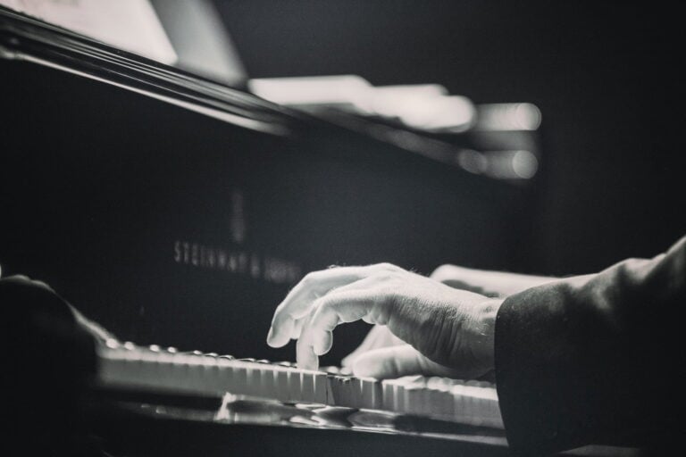 man playing piano black and white