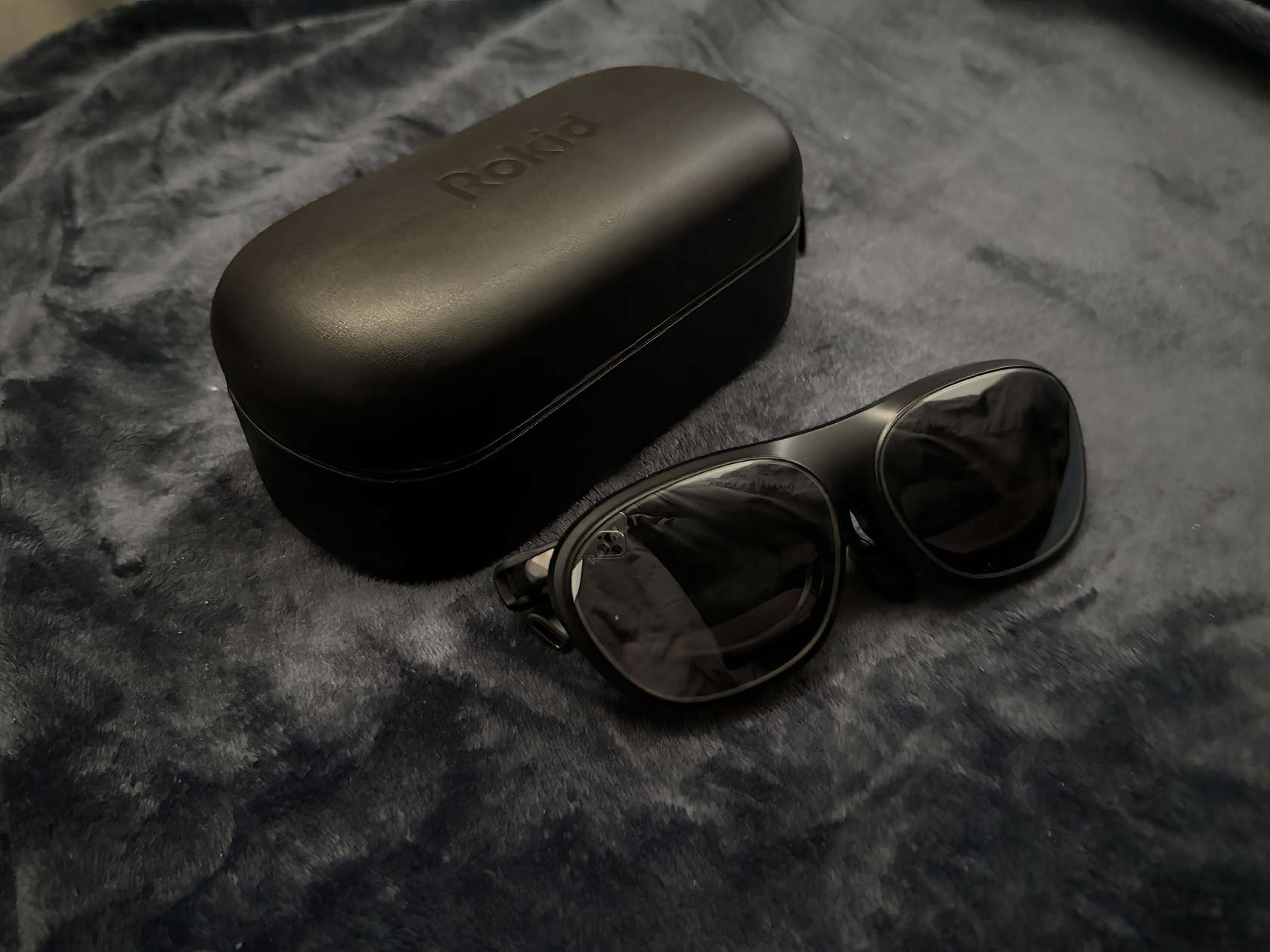 A pair of Rokid Max 2 AR glasses and a blackout cover on a white desk in soft natural light. Rokid Max 2 Review 3