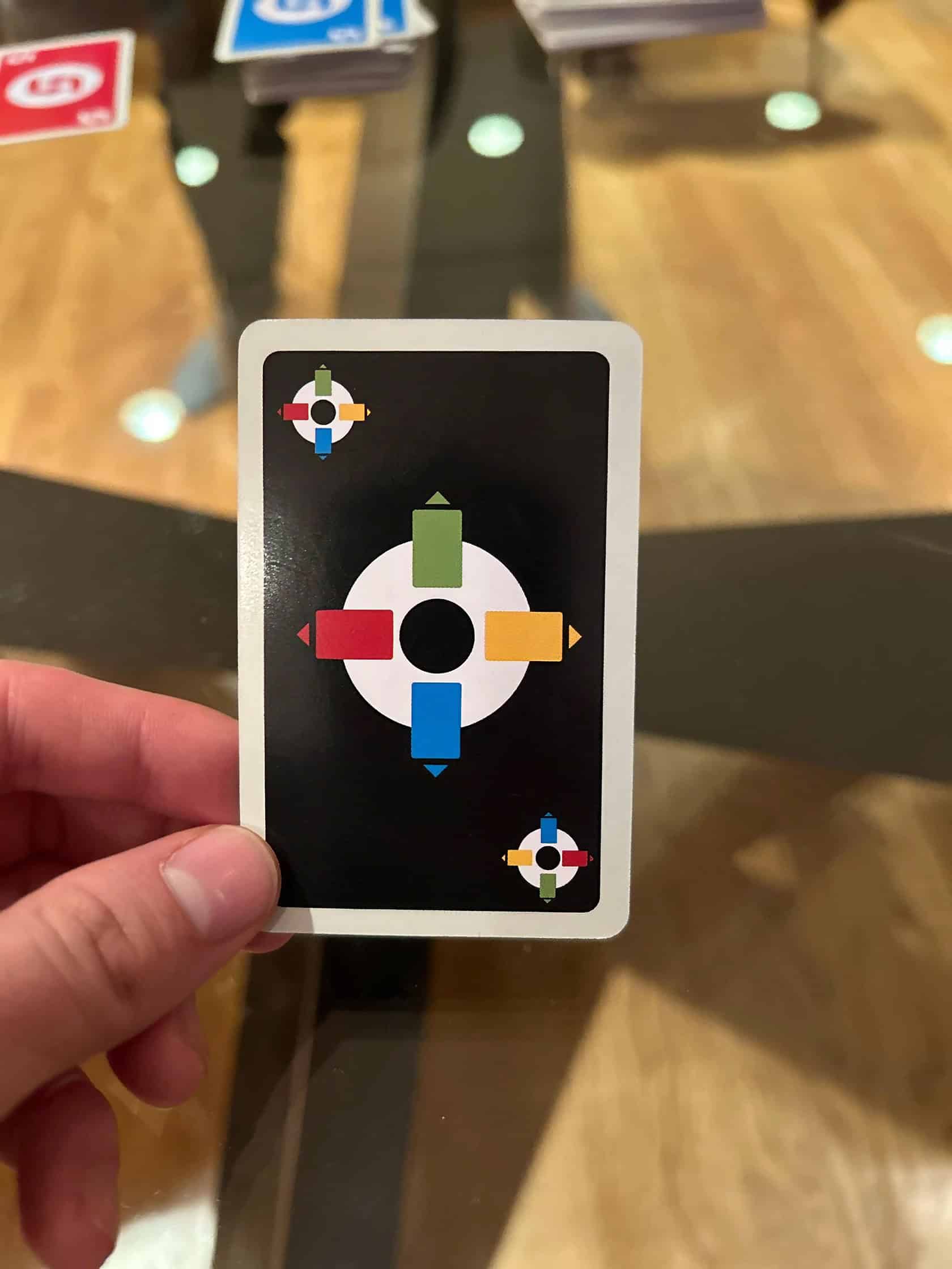 A group of young adults playing Uno in a warmly lit living room. Uno Mod Game 6