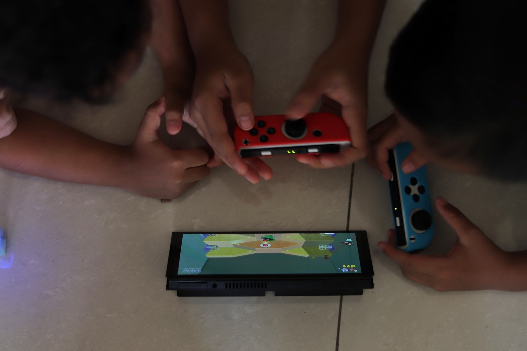A couple enjoys gaming together on a couch, focused on their Nintendo Switch consoles in a cozy living room. Free Nintendo Switch Games 1