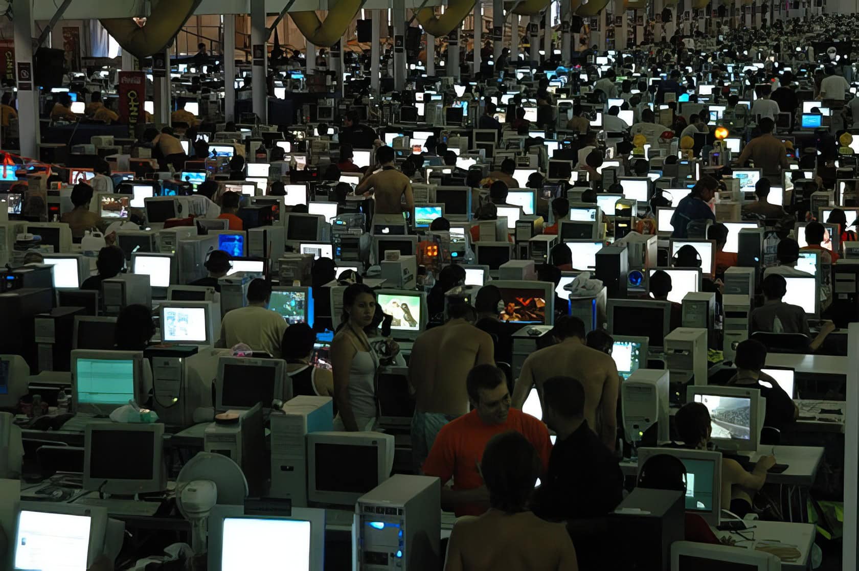 A well-organized home office features a laptop, WiFi router, and a focused individual managing network settings. What Do You Need for LAN Party Fun 7