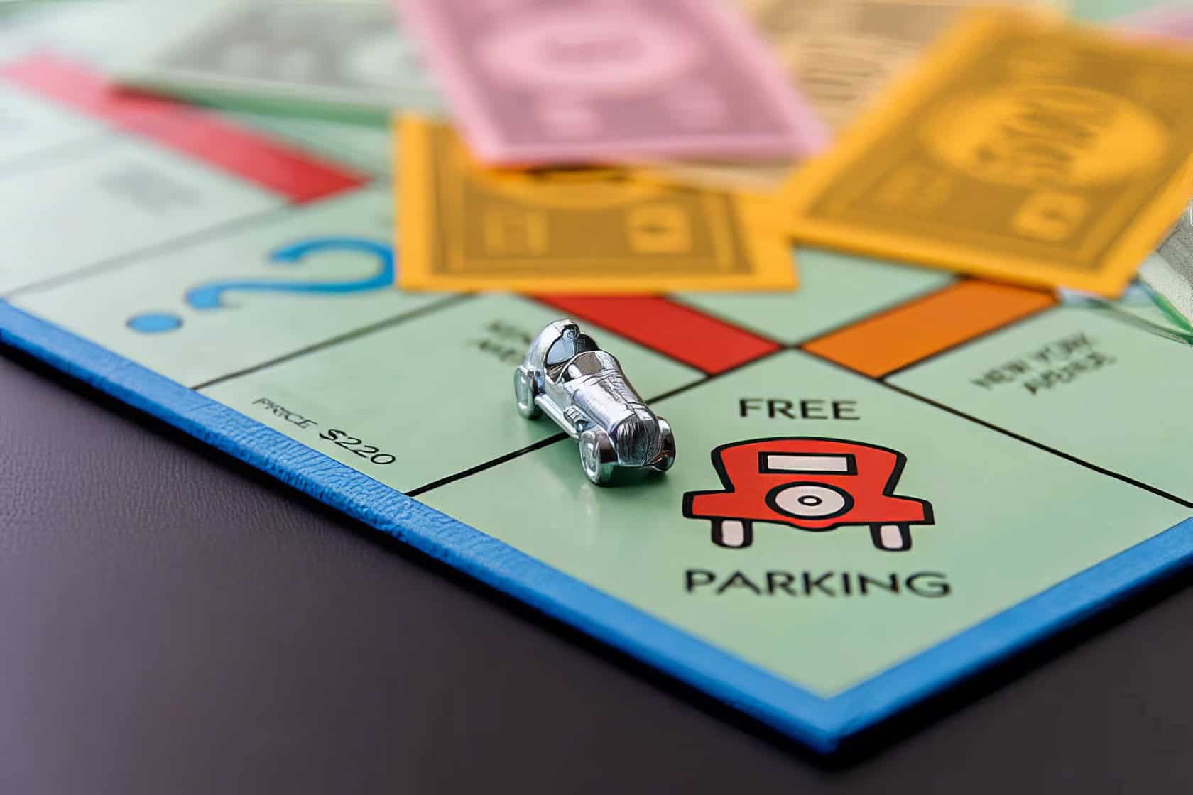 A well-worn Monopoly board with game pieces and play money is set on a polished oak table, suggesting a cozy game night. What Does Free Parking Mean In Monopoly 4