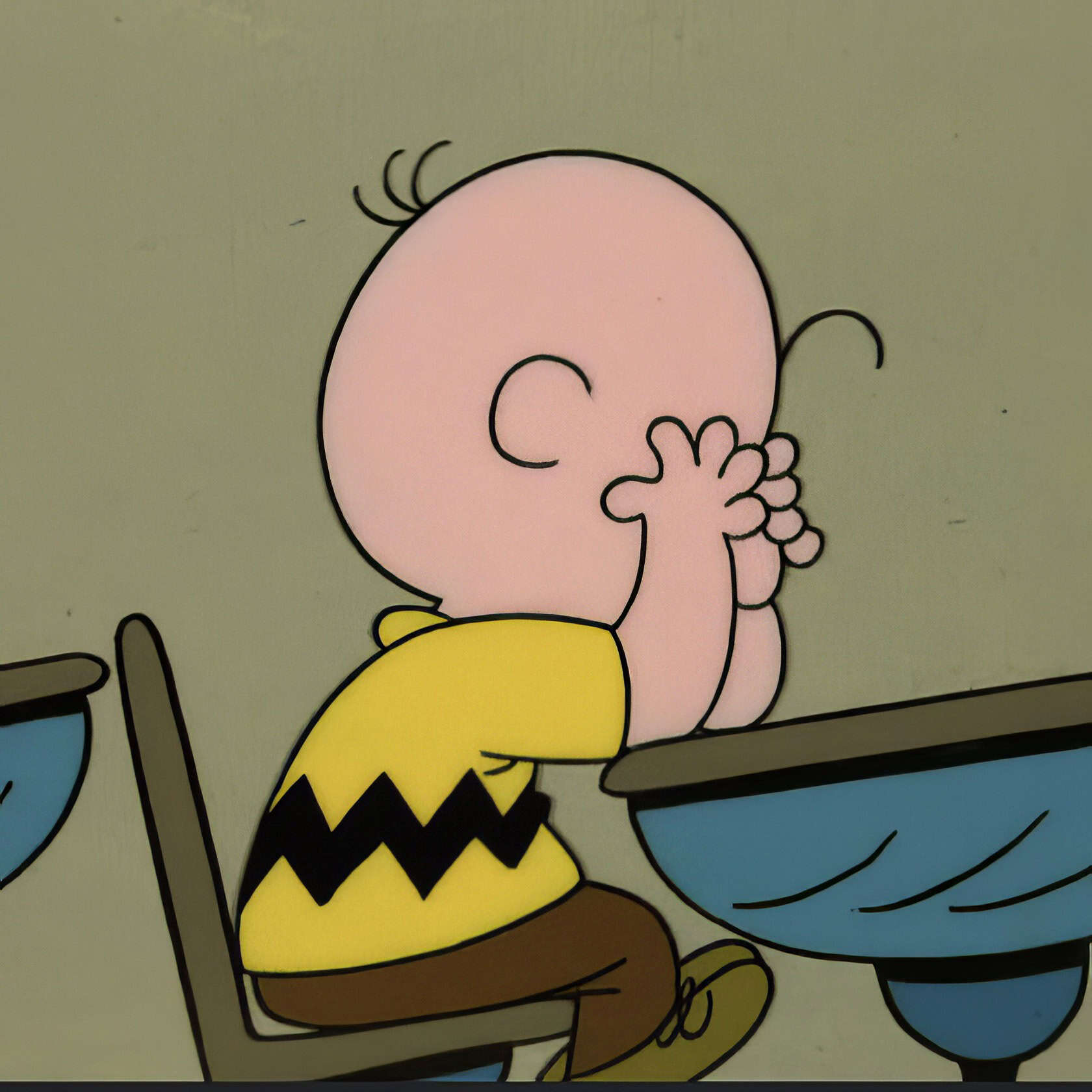 Depression in Cartoons: 12 Key Lessons from Eeyore to BoJack 10 Bright cartoon of Charlie Brown from Peanuts franchise, sitting at a table with a thought bubble, emphasizing nostalgic and animated content related to geek culture and classic animations.