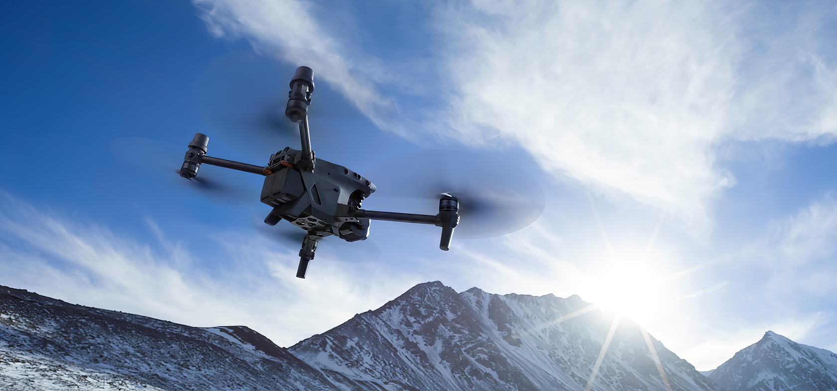 A mid-30s man casually inspects a DJI Matrice 30T drone in a slightly messy forest shrouded in fog. High-tech drone flying over snow-covered mountains during daytime with a bright sun in the sky.