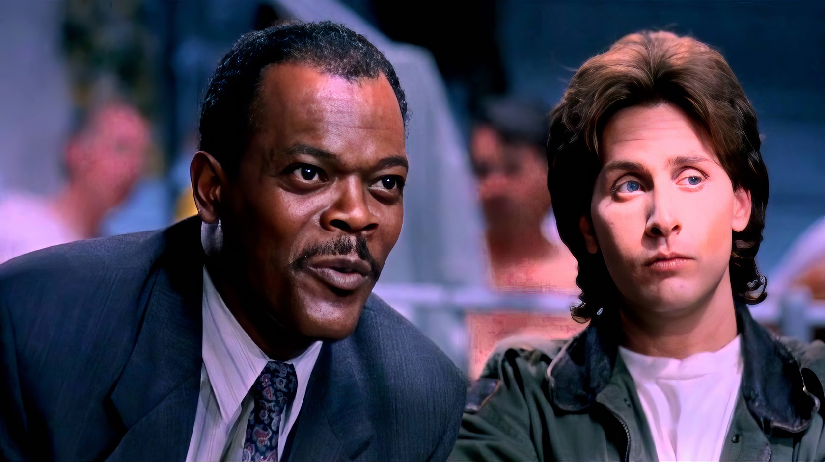 The Legacy of Loaded Weapon 2: A Deep Dive Into the Unmade Sequel 2 African American man speaking animatedly, wearing a suit in a lively setting with a young boy with shaggy brown hair, casual jacket, in the foreground at a social event or gathering.