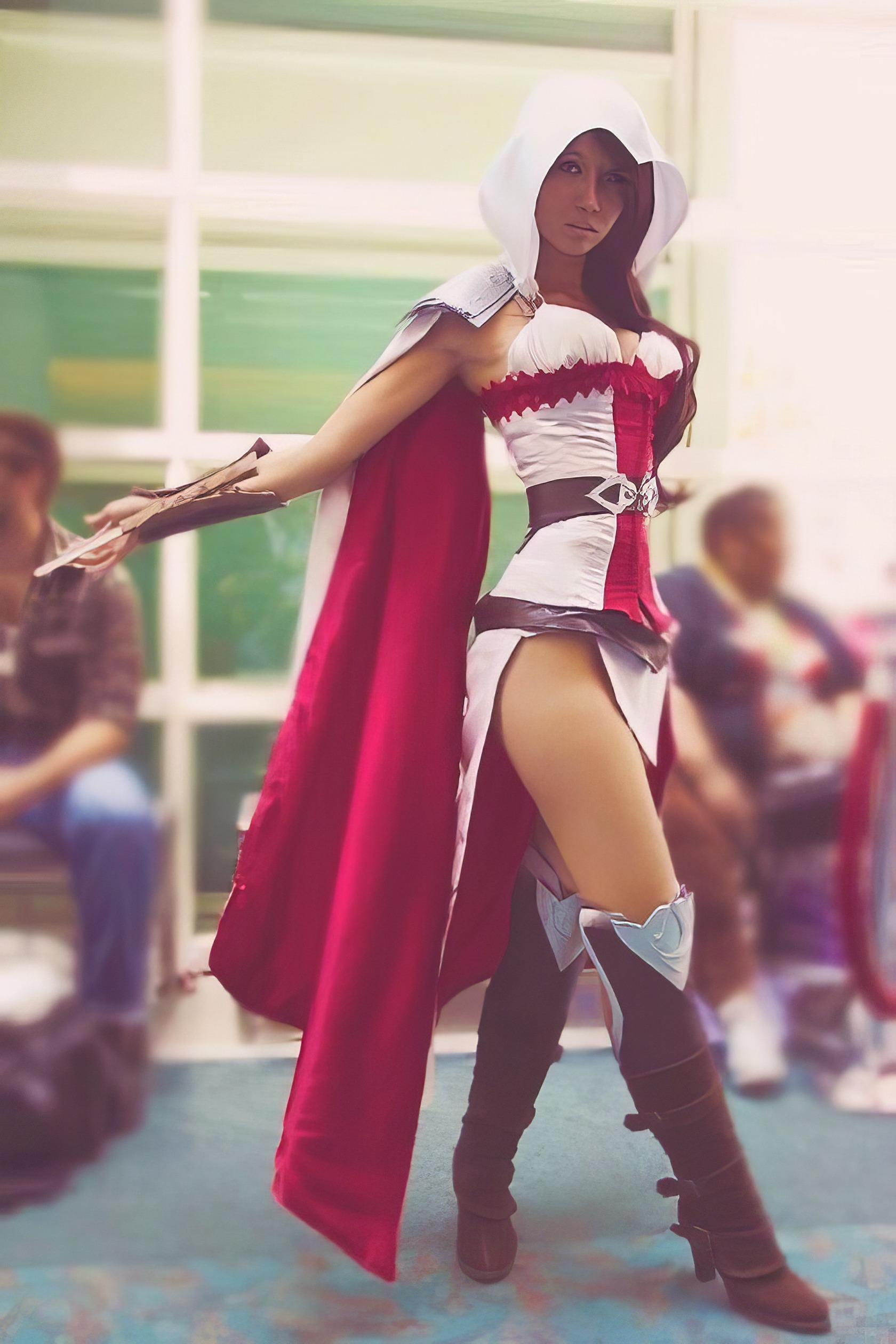 Assassin's Creed Hot Cosplay: 20+ Character Costumes & DIY Tips 11 Cosplay of a fantasy warrior woman with a hood, red and white costume, thigh-high boots, and a cape at a convention.