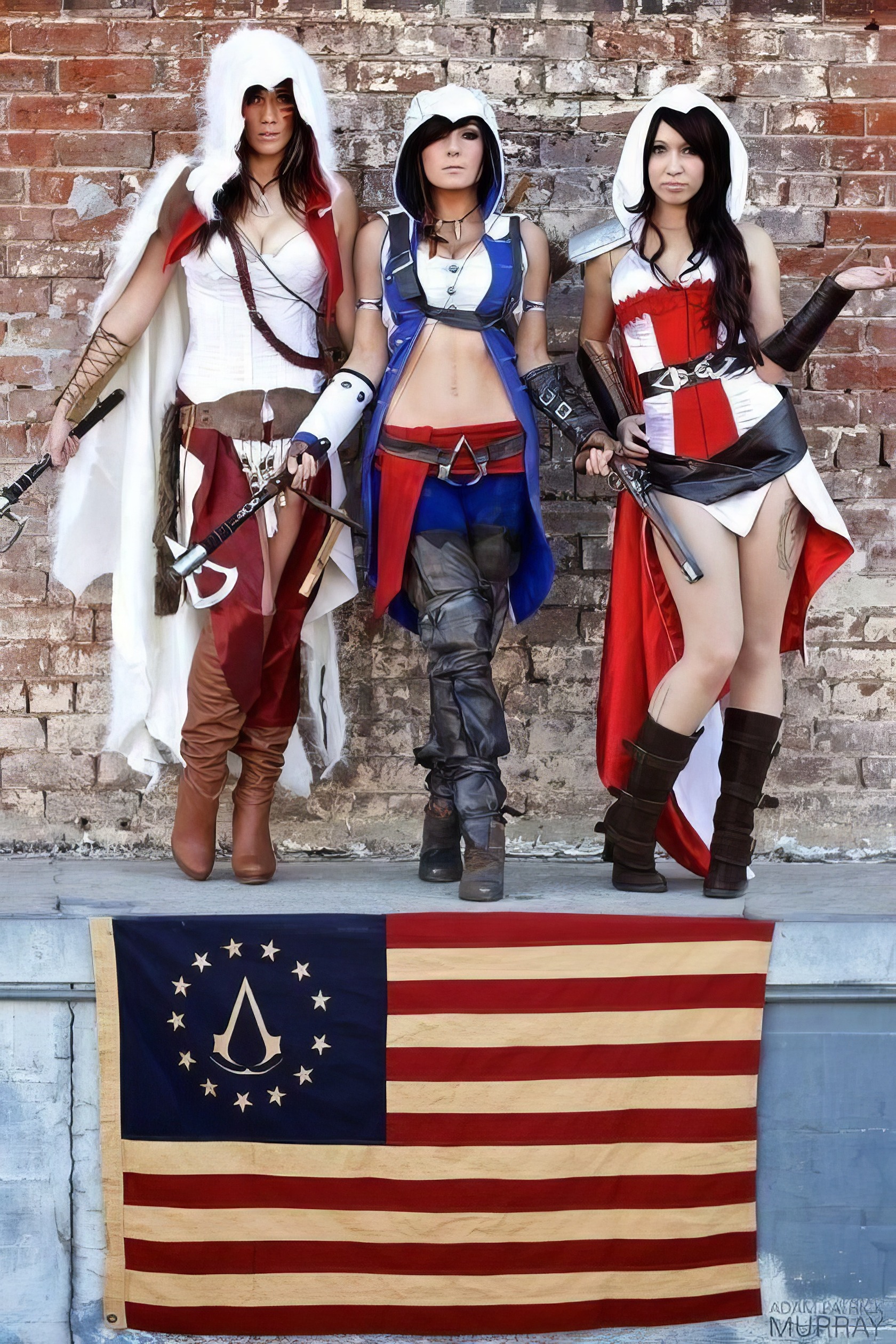 Assassin's Creed Hot Cosplay: 20+ Character Costumes & DIY Tips 6 Fierce women cosplaying as video game characters, standing on a brick wall with a patriotic flag, showcasing detailed costumes and confident poses in an urban setting.
