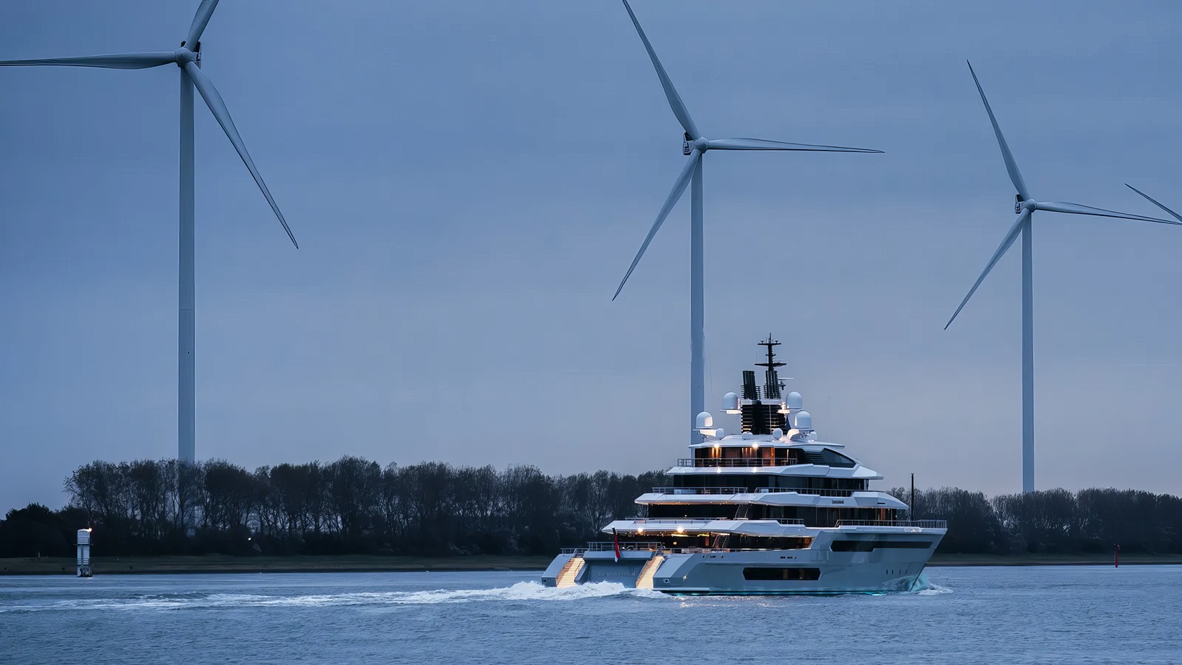 Gabe Newell's Superyacht: 5 Bold Ideas Behind Leviathan 3 Sailing yacht cruising in a waterway with wind turbines in the background, showcasing renewable energy and luxury maritime technology.