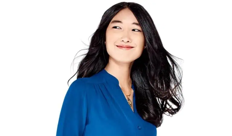 Elegant Asian woman with long black hair wearing a blue blouse, smiling confidently, showcasing style and professionalism for optima branding and tech-inspired visuals.
