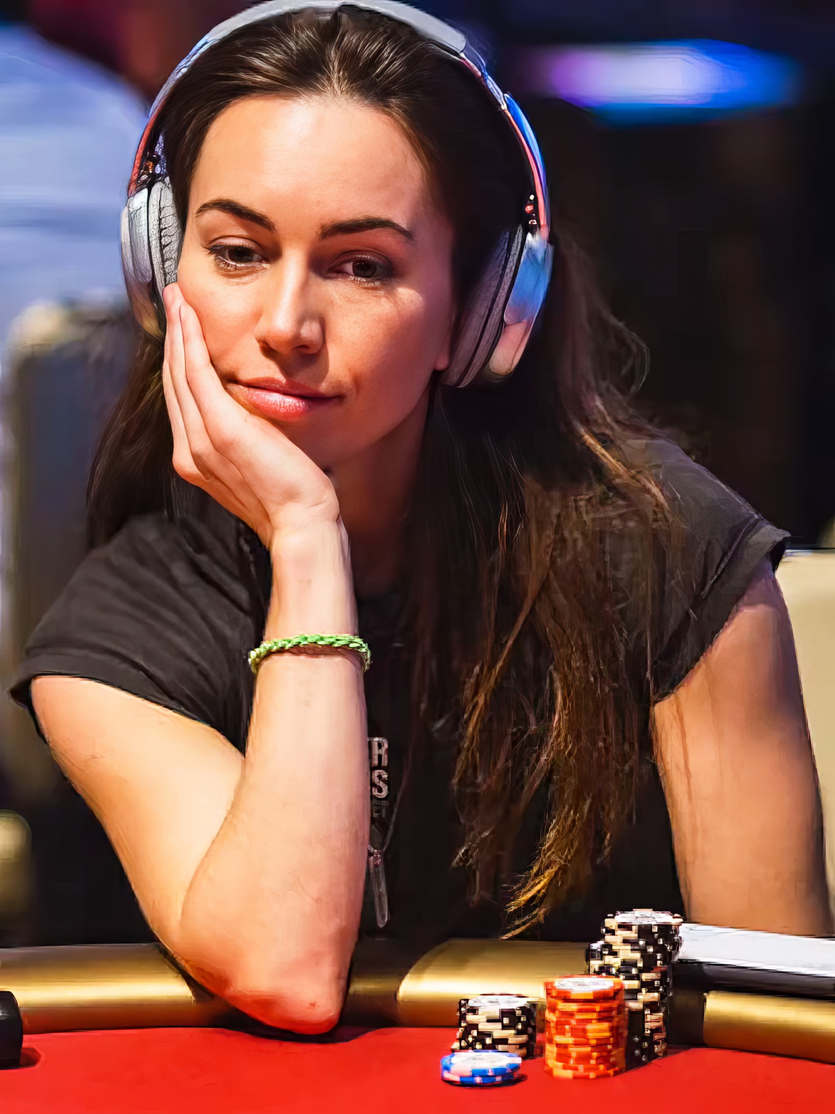 Liv Boeree Poker: 8 Lessons from Astrophysics to WSOP 2 Focused woman with headphones at poker table, contemplating her move during a casino game, surrounded by poker chips and gambling accessories.