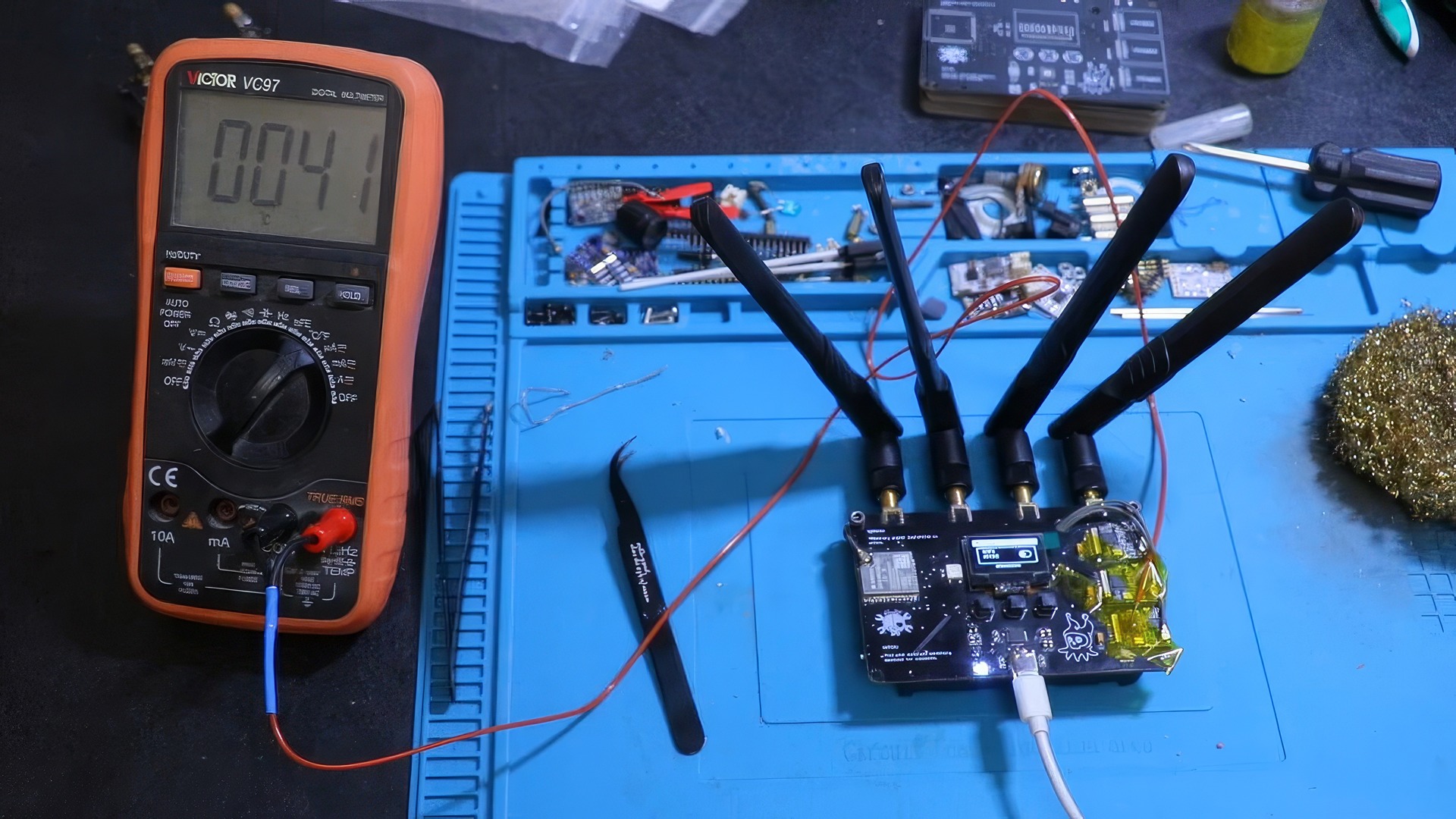 RF-Clown V2: 10 Big Upgrades for Smarter RF Hacking 5 High-precision digital multimeter testing electronic components on a workbench with a blue anti-static mat and various tools.