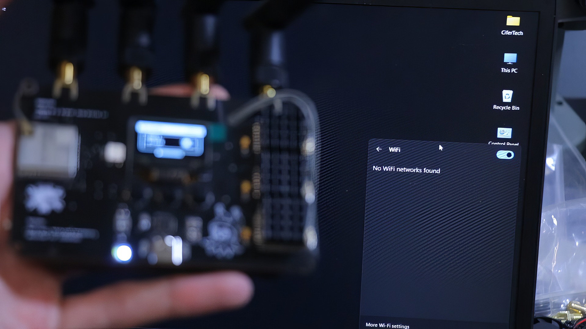 RF-Clown V2: 10 Big Upgrades for Smarter RF Hacking 7 A person holding a graphics card or electronic component in front of a monitor displaying Wi-Fi settings with no networks found, illustrating PC hardware and connectivity troubleshooting.
