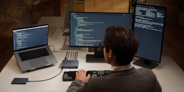 High-resolution image of a person working with multiple monitors connected to the UGREEN Revodok Maxidok 10-in-1 Thunderbolt 5 Dock, showcasing its connectivity and versatility.