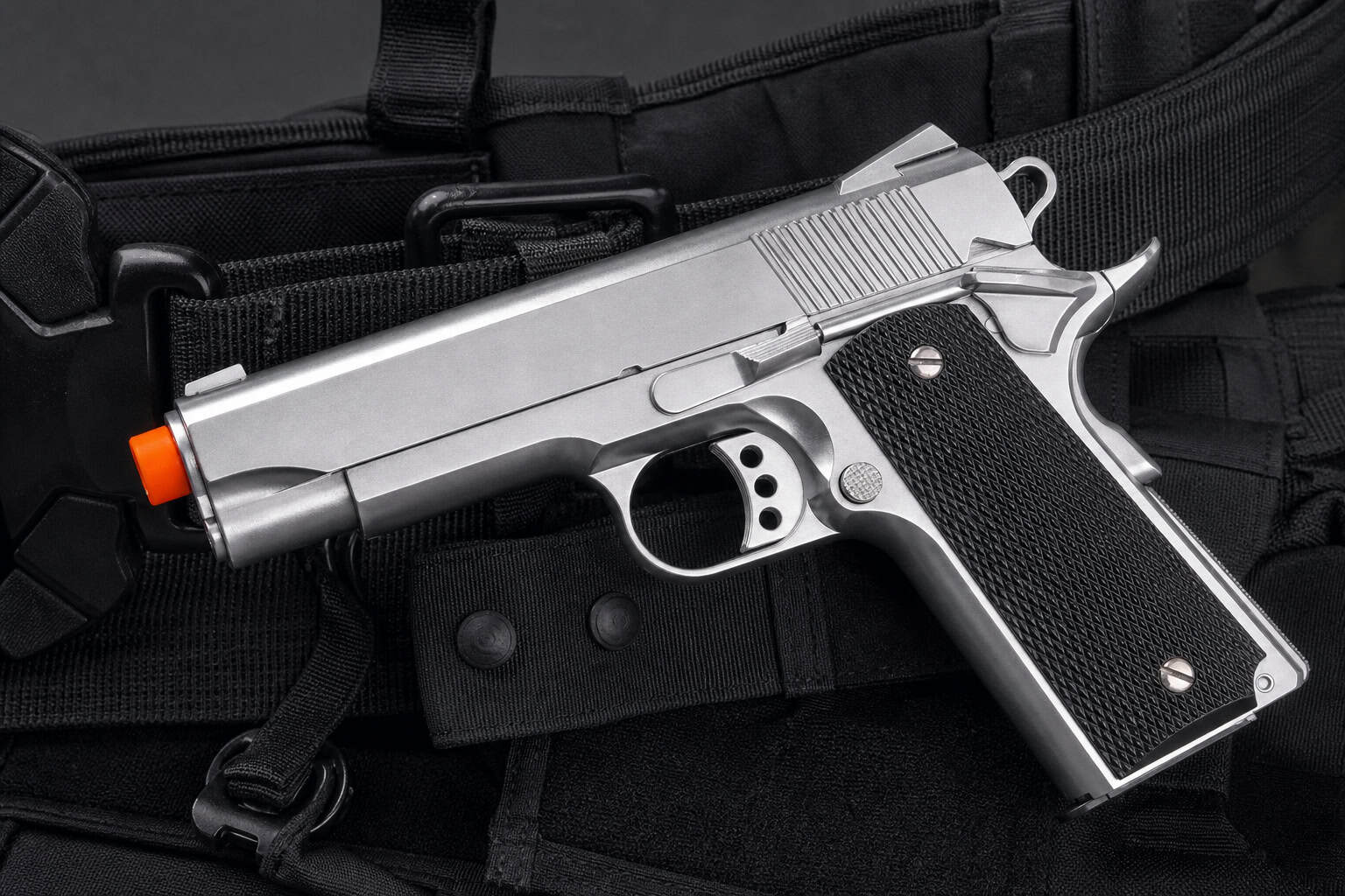 Hot Lara Croft Cosplay: 69+ Photos & DIY Build Guide 70 Close-up of a silver semi-automatic pistol with black grip, placed on tactical gear, highlighting firearm details and design.