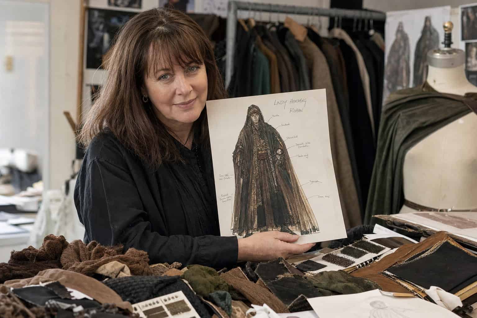 Angelina Jolie's Tomb Raider Costume: The Shorts Controversy and Lindy Hemming's Design 3 Oscar-winning costume designer Lindy Hemming on set with a sketch and fabric swatches in muted earth tones.