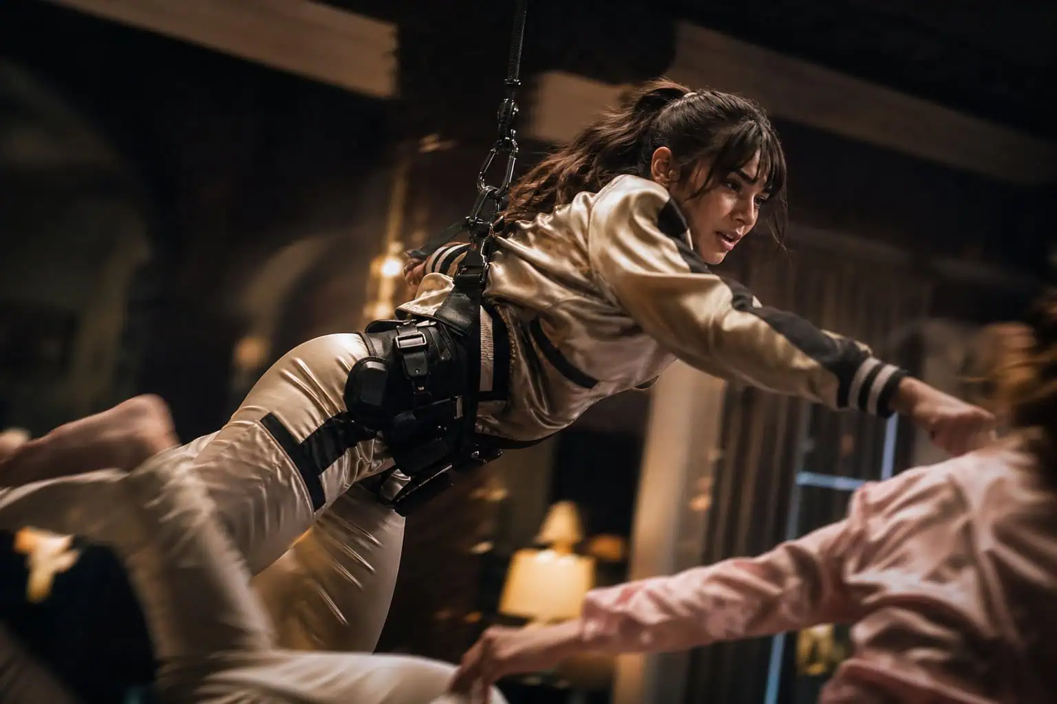 Angelina Jolie as Lara Croft in a silk pajama fight scene, hanging in a harness with a utility belt.