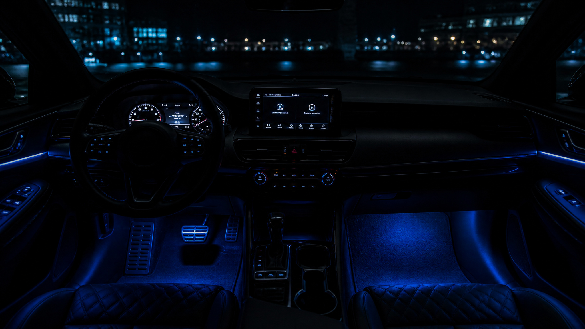 Interior of a luxury car illuminated with blue ambient lighting, showing the dashboard, steering wheel, and center console at night.