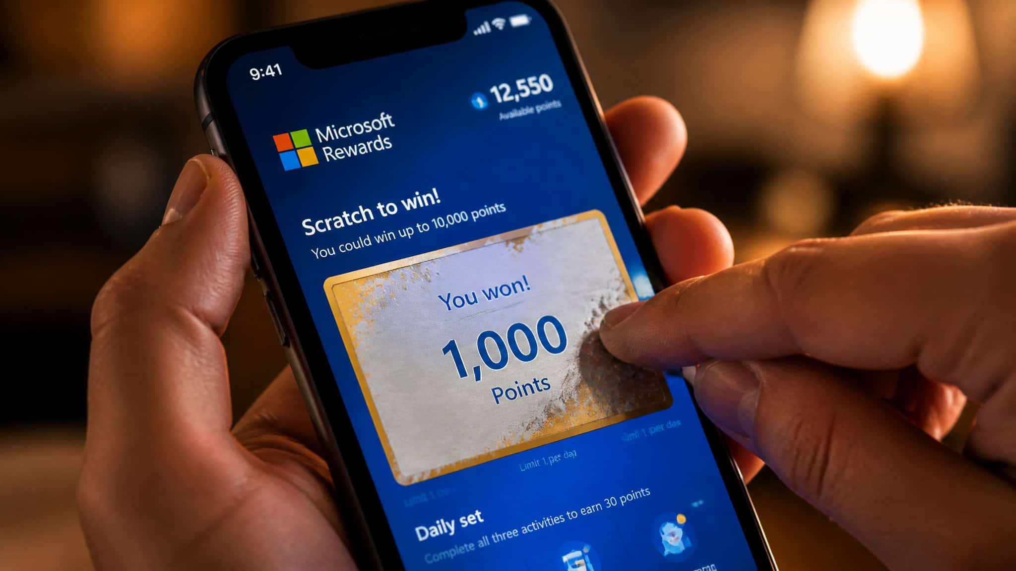 Hand scratching a digital Microsoft Rewards card on a smartphone screen