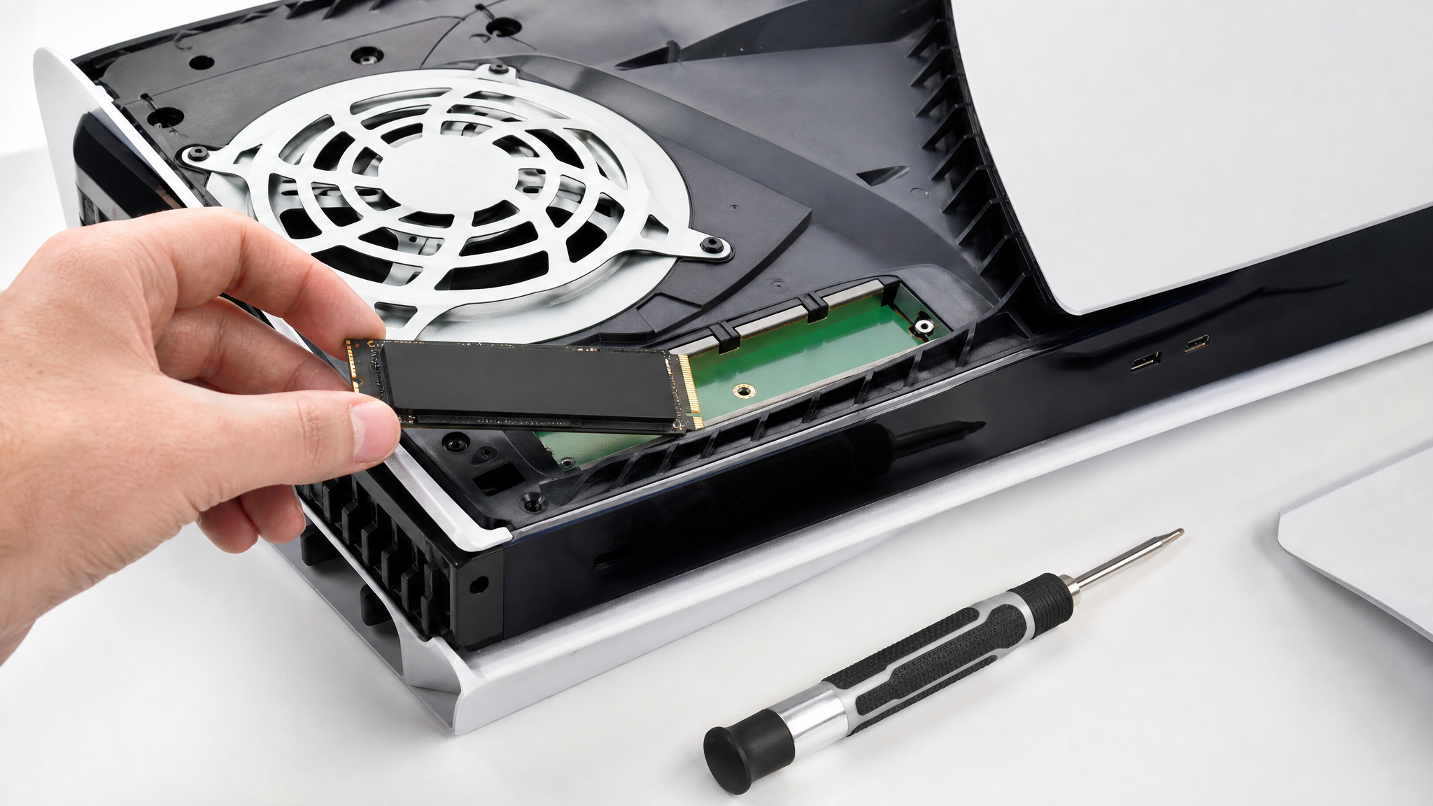 What to Get a Gamer: 20 Gifts That Fix Real Problems 3 Installing a Samsung 990 Pro M.2 SSD into a PlayStation 5, expanding storage for more games.