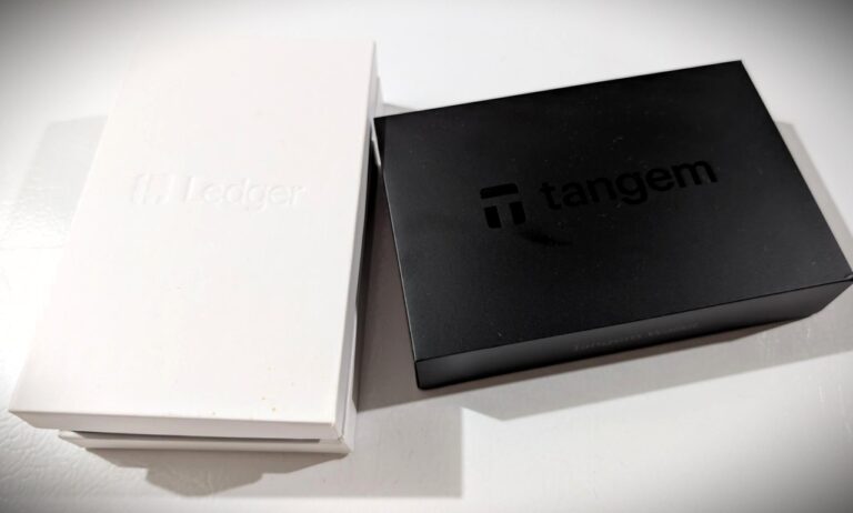 Image shows Tangem wallet packaging with white and black boxes on a white surface.