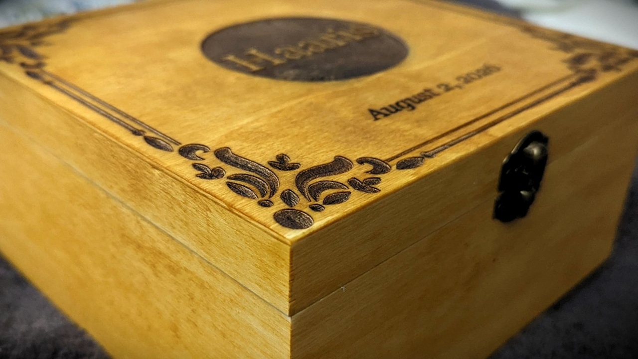 WeCreat Lumos Flex Review: Where the Metal Claims End and MOPA Begins 11 Close-up of a wooden box with ornate black metal latch and engraved details, used for storing or gifting, with a vintage appearance.