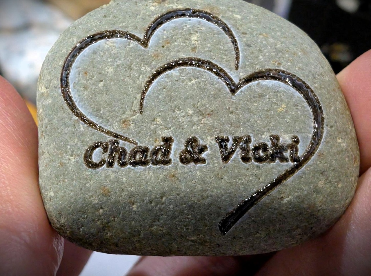 WeCreat Lumos Flex Review: Where the Metal Claims End and MOPA Begins 9 Heart-shaped stone engraved with 'Chad & Vicki' and a heart outline, held between fingers, symbolizing love and connection.