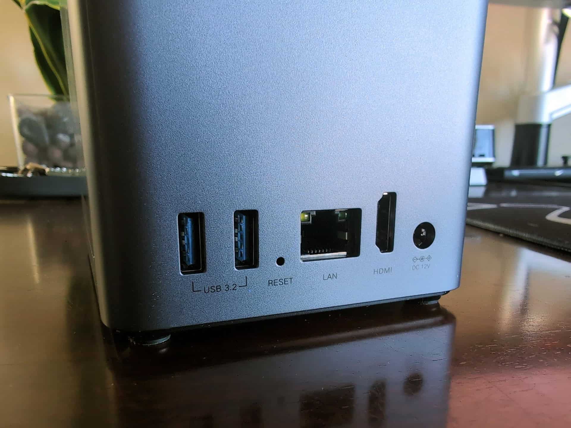 Ugreen DH2300 vs DXP2800 GT: Which Two-Bay NASync Should a First-Time Buyer Actually Get? 3 Close-up of a two-bay NAS device showing USB, LAN, HDMI ports, and reset button on a wooden surface.