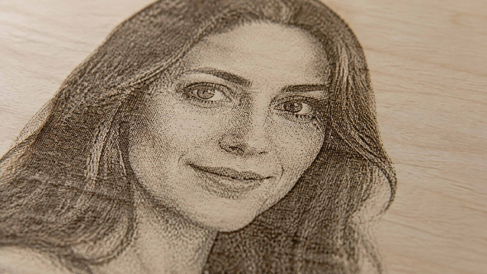 Dithered grayscale portrait engraved on fine-grained basswood showing wide tonal range